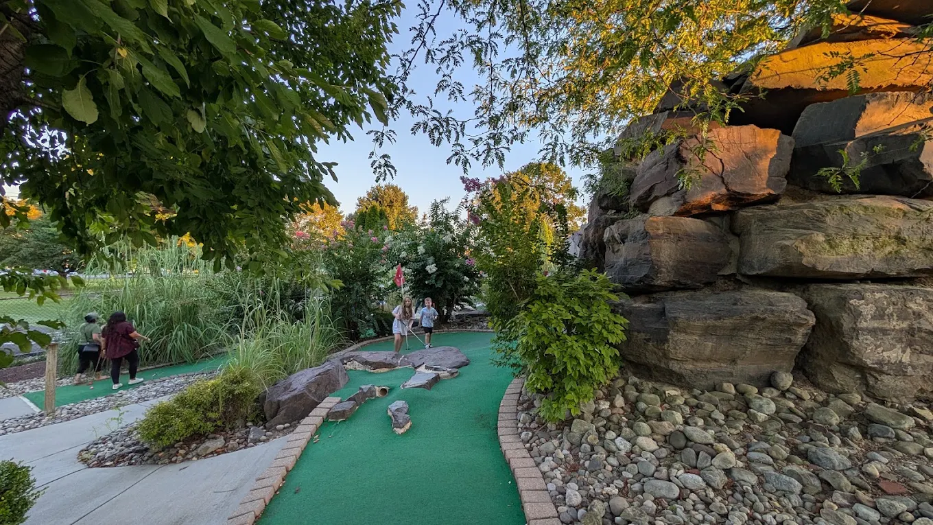 Group enjoying mini golf at golden hour
